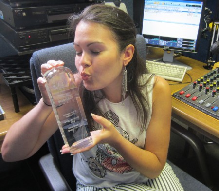 Kelly in the studio, with award